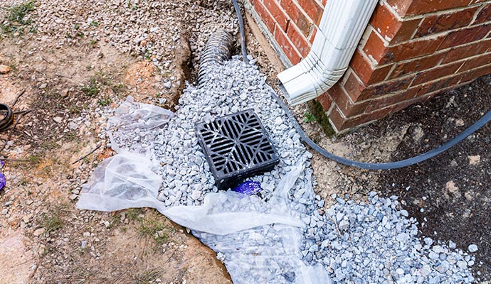 Foundation drainage system with downspout installed to manage water runoff