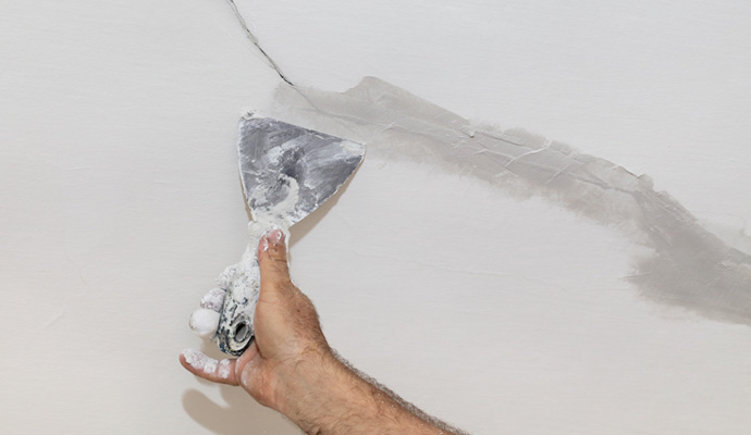 professional fixing a crack on the wall