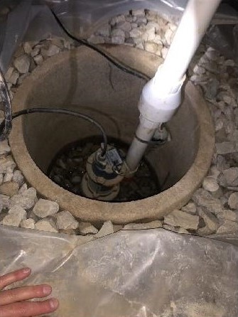 Newly installed sump pump in a crawl space, crucial for effective crawl space waterproofing and moisture control. This drainage solution prevents standing water, protecting your property from damage and improving air quality.