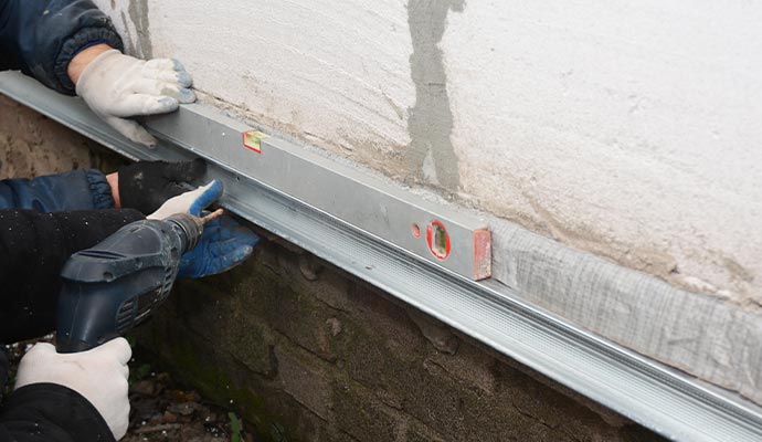 Installation of metal wall bracing system on a foundation wall