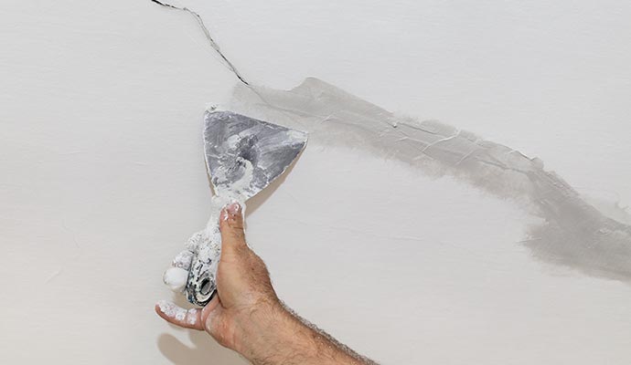 worker repairing wall crack